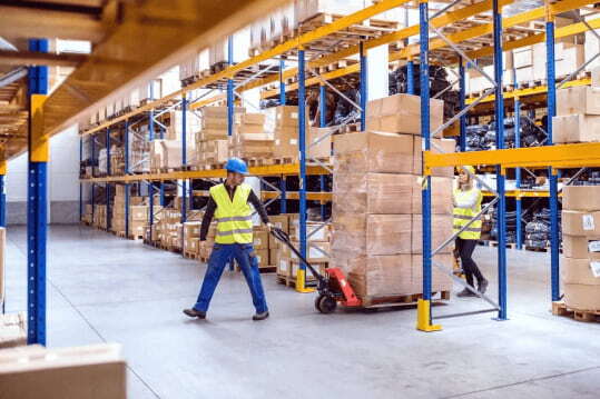Employees restocking warehouse shelves at NSJ Wholesale to maintain product availability
